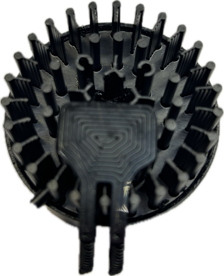 En rund komponent med många stift och en platt del i mitten.