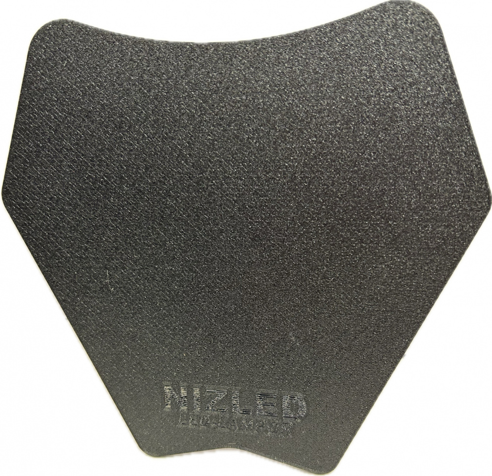 Skyddsplåt för lamphus, svart och formad som en hexagon.