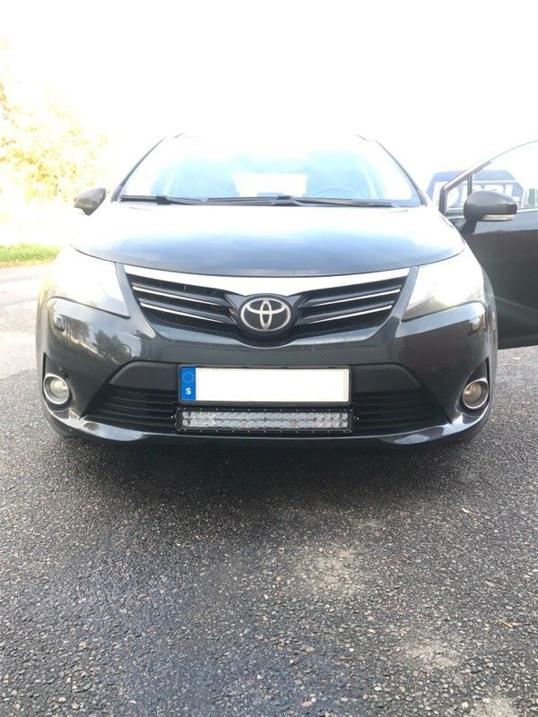 En svart bil med en nummerplåt monterad fram.