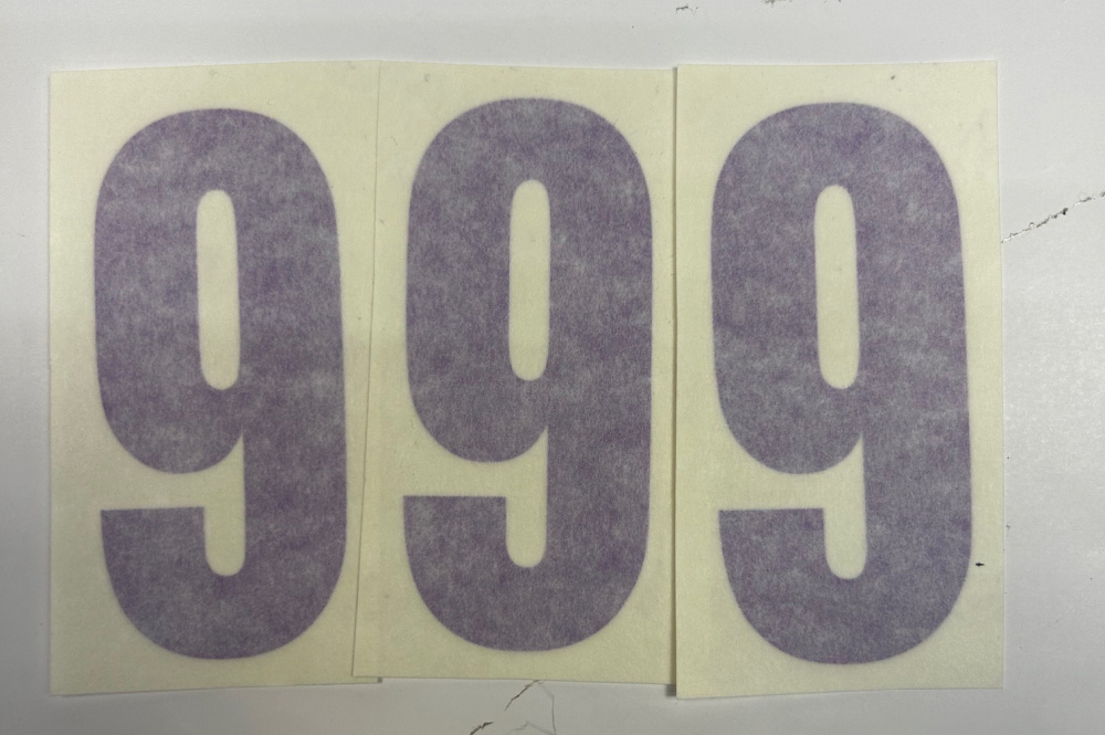 Tre lila siffror 9 på klistermärken.