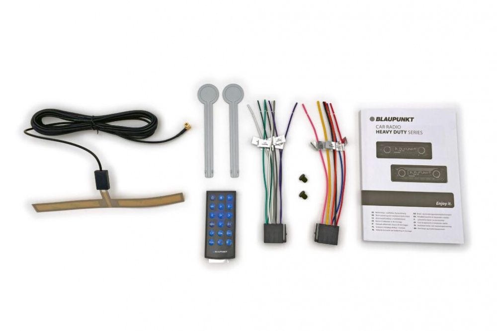 Bilden visar en bilstereo med tillbehör och handbok.