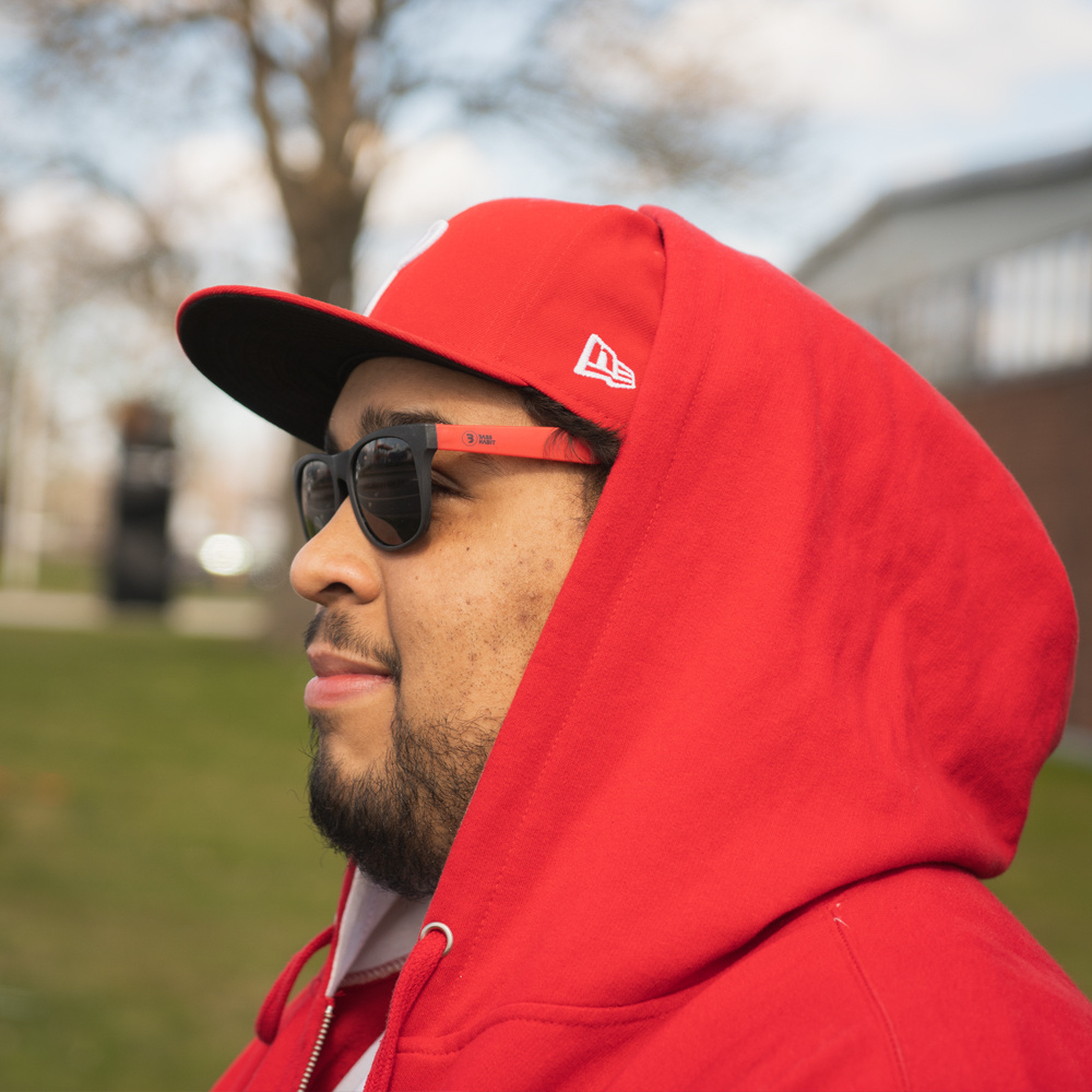 Röda och svarta solglasögon, person med kapsyl och röd hoodie.