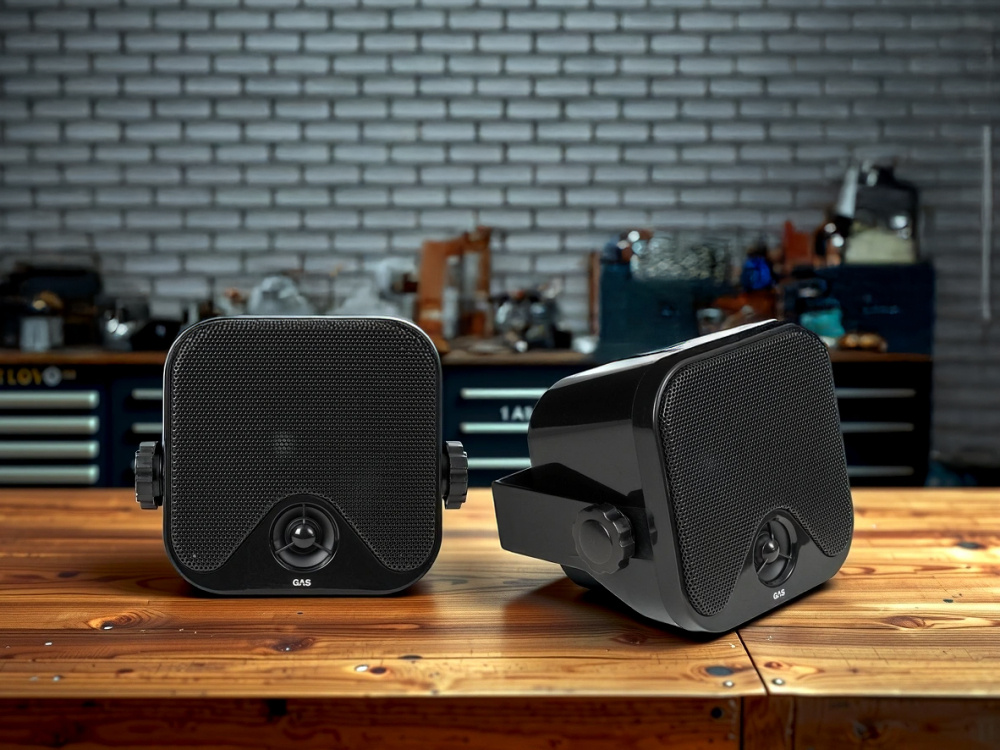 Två svarta 2-vägs lådhögtalare på en träbänk.