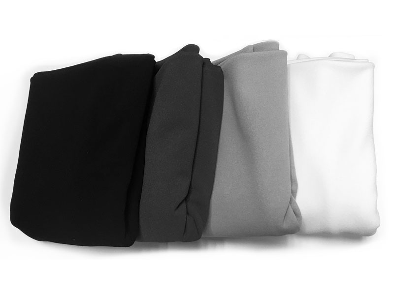 Fyra hopvikta tygstycken i svart, mörkgrått, ljust grått och vitt.