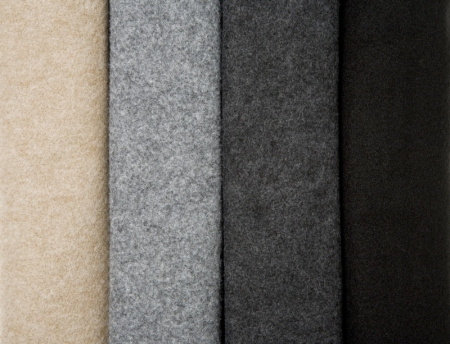 Fyra tygprover i olika nyanser: beige, grå, mörkgrå och svart.