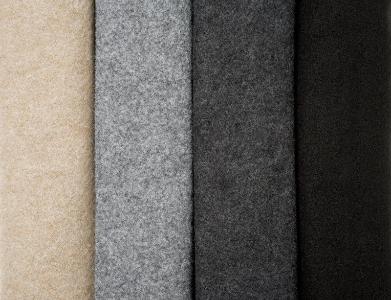 Fyra tygstycken i olika färger: beige, grå, mörkgrå och svart.