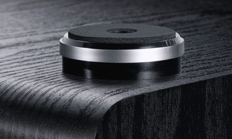 En svart subwoofer med en rund bas och metallisk kant.