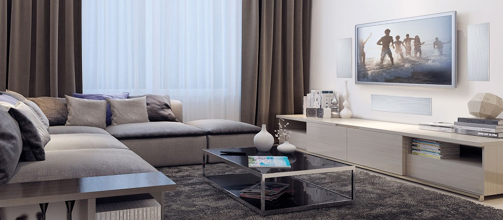 Ett modernt rum med en soffa, TV och inbyggnadshögtalare.