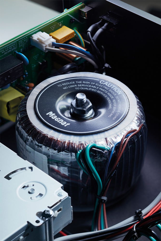 En stor transformer med kablar inuti en elektroniklåda.