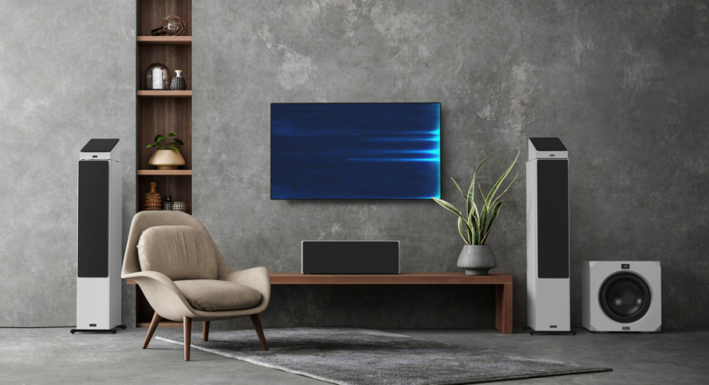 Ett modernt vardagsrum med mattsvart centerhögtalare, TV och högtalare.