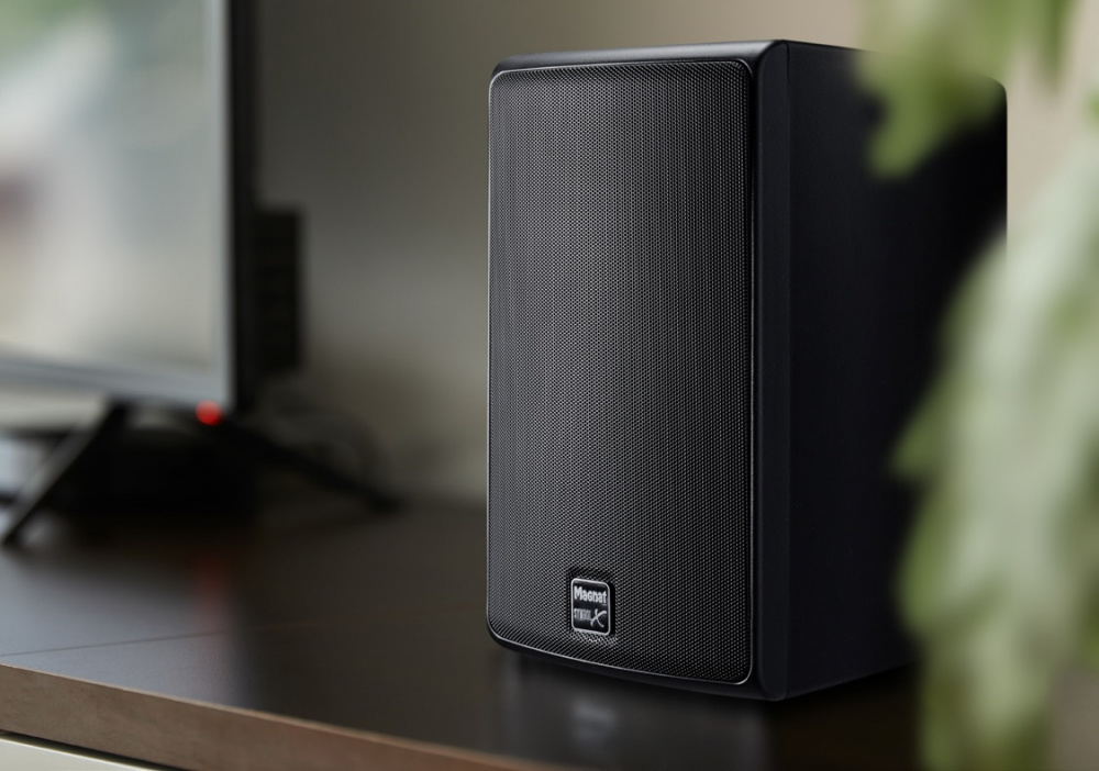 Högtalare i svart, designad för utomhusbruk, placeras på en yta.