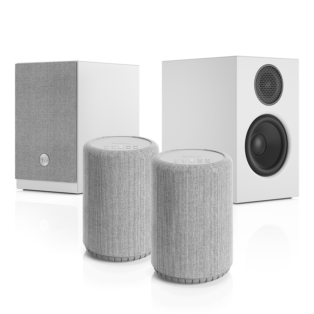Högtalarpaket med två små och en större enhet i vit och grå design.