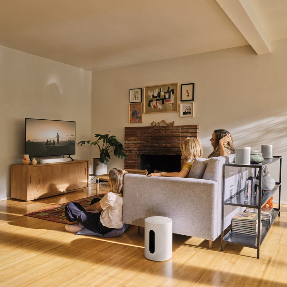 En familj vid TV:n med en ljudanläggning i ett ljust rum.