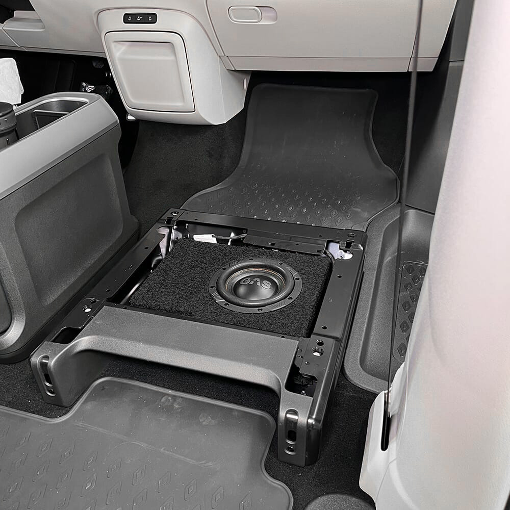 Ljudsystemkomponent under sits, med subwoofer och installationstillbehör.