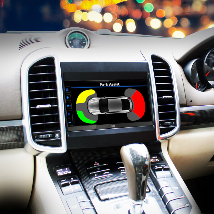 En bild av en bilinteriör med JVC-skärm och parkeringsassistans på displayen.