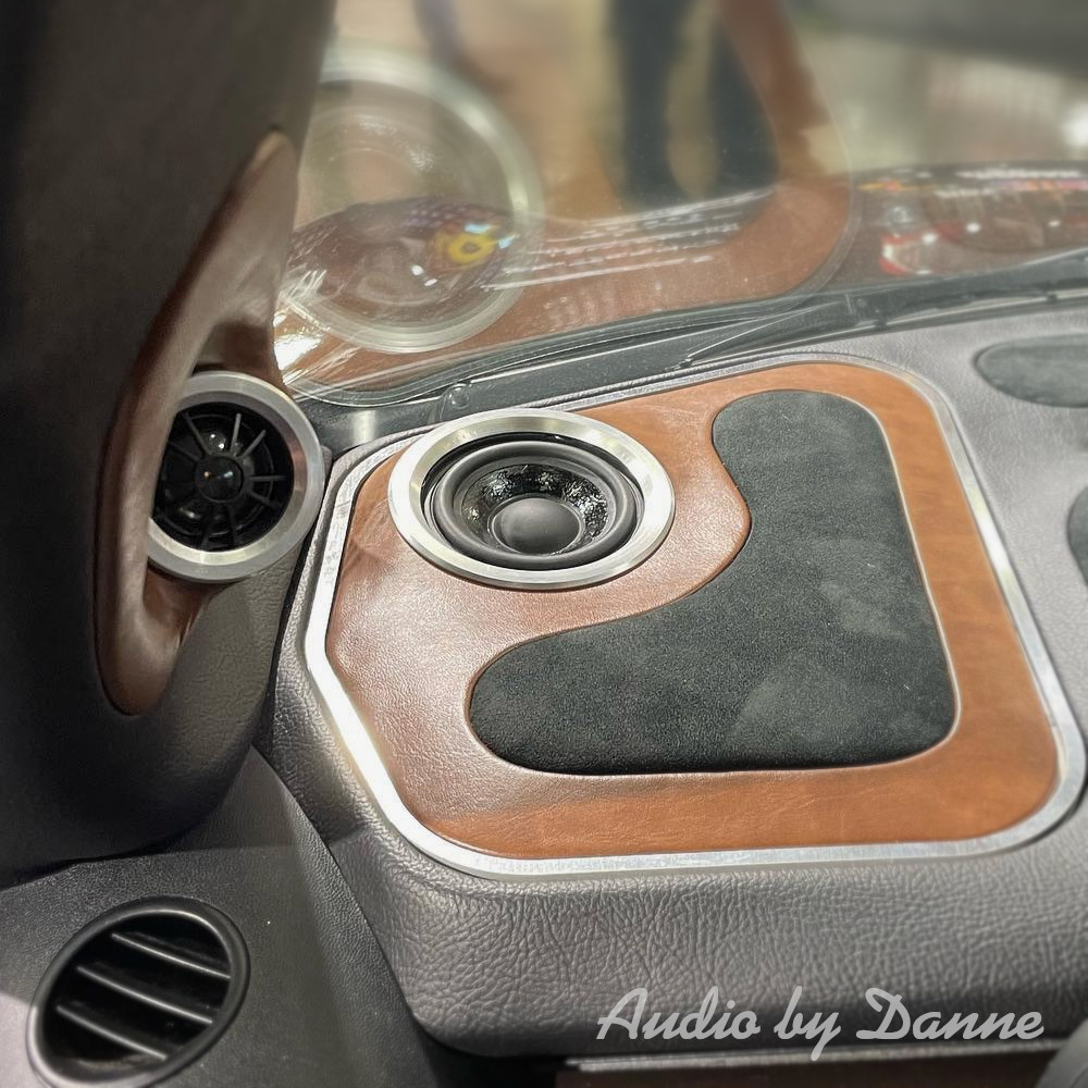 Högtalarljudsystem med elegant inredning i bil, runda och kvadratiska element.