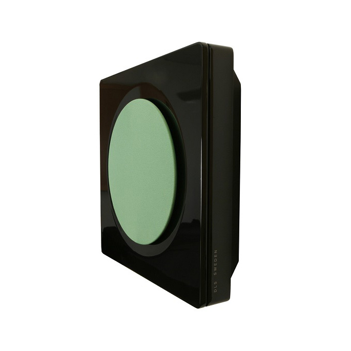 Svart högtalare med rund grön front, modern design för väggmontering.