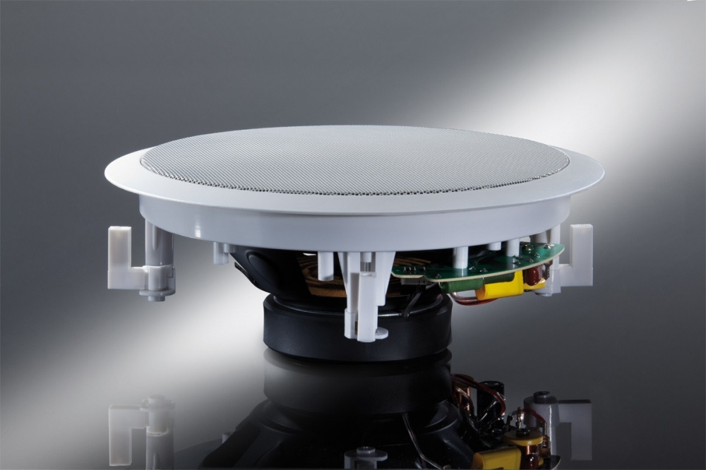 En rund högtalare med grå galler och synlig teknik under.