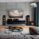 Klipsch R-800F & R-121SW 2.1 högtalarpaket, svart Ett modernt rum med svart ljudsystem, tv och stilrena möbler.