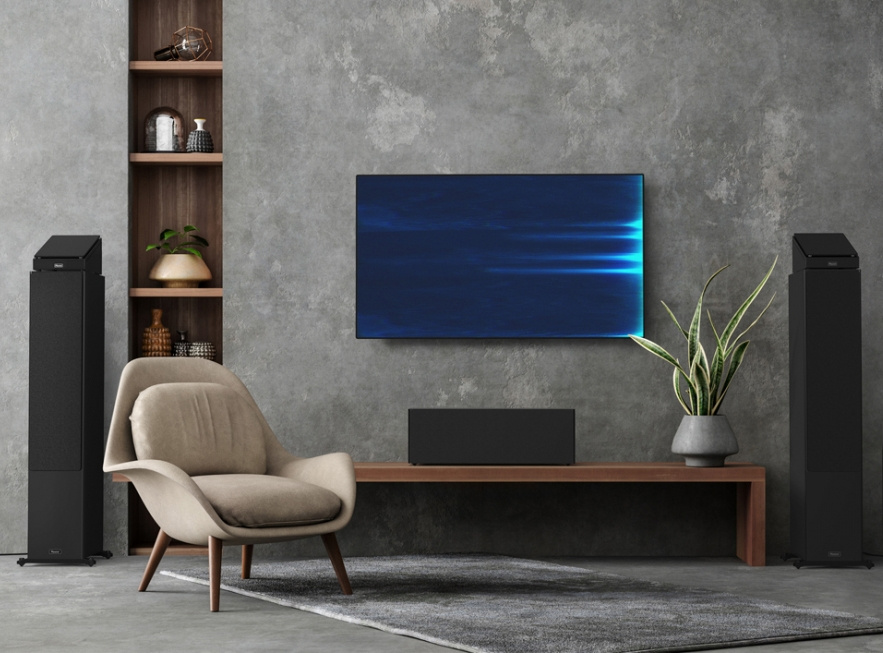 En modern inredning med högtalare, TV och en bekväm fåtölj.