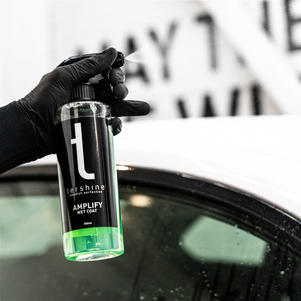Flaska med Tershine Amplify Wet Coat i hand, sprayad på bilyta.