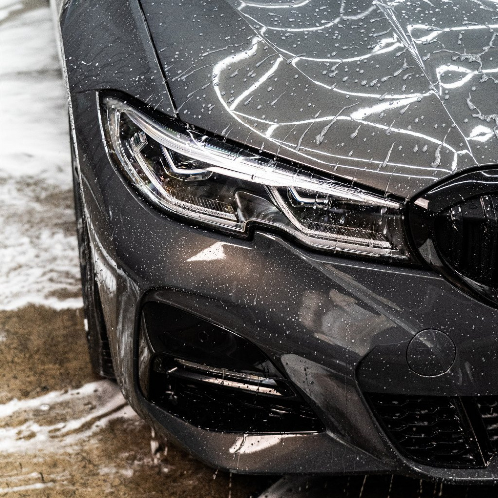 En tvättborste med schampo syftande på rengöring av en bil.