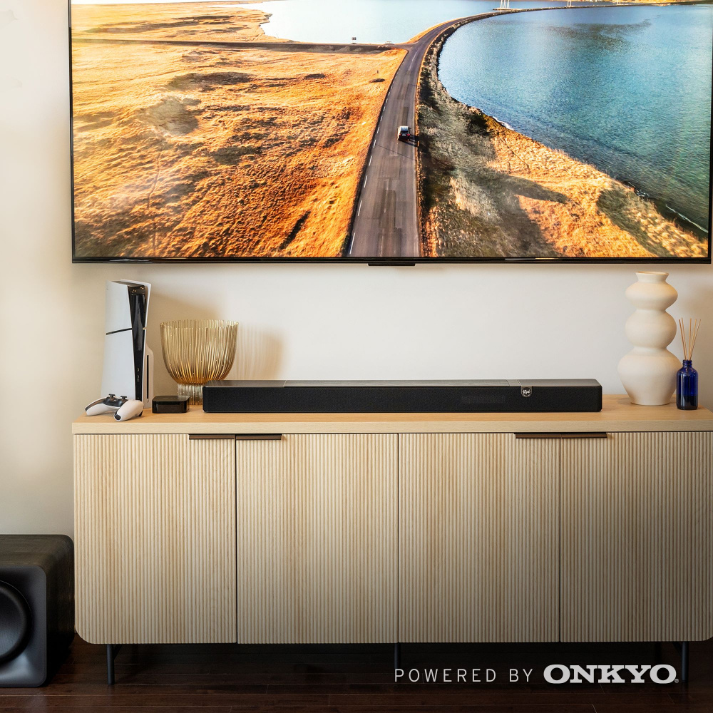 En modern inredning med en soundbar och subwoofer under en stor TV.